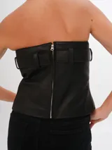 Top strapless de cuero marrón con hebilla plateada y ojales.