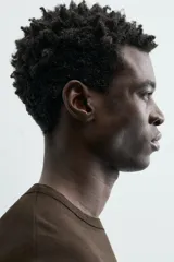 Camiseta de corte relajado (relaxed fit) color blanco roto o crema, con cuello redondo y manga corta.