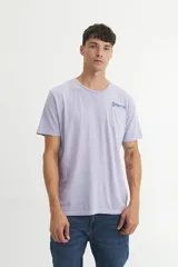 Remera de algodón color lavanda con cuello redondo y bolsillo en el pecho con inscripción en azul.