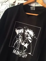 Remera negra de algodón con estampado de dos personajes de anime en blanco y texto "MAKOSH".