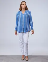 Camisa celeste con rayas verticales blancas y azules, cuello mao, escote en V y cierre frontal con botones.