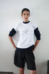 Remera blanca de manga corta con cuello redondo y estampa frontal de estrella plateada.