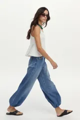 Jean balloon de color azul con lavado vintage, tiro medio, diseño amplio en las piernas y dobladillos inferiores elastizados.