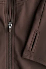 Campera deportiva marrón con cierre frontal y cuello alto, confeccionada en tejido SoftMove. Cuenta con mangas largas que incluyen abertura para el pulgar.