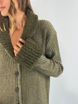 Saco marrón con rayas verticales en tonos beige, con cuello y puños de tejido rizado. Cierre frontal con botones.