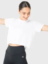 Remera de corte cropped, color blanco, con cuello redondo y mangas cortas. Confeccionada en tela texturizada, ideal para actividades deportivas o uso casual.