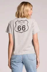 Remera gris melange de corte holgado, manga corta y cuello redondo, con estampa frontal que incluye la frase 'On the Road Again', el nombre 'Willie Nelson' y una rosa roja con tallo verde.