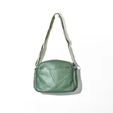 Bandolera verde de cuero sintético con correa de tela estampada ajustable. Presenta bolsillo externo con cierre y diseño geométrico en el frente.