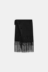 Falda corta de tiro medio, color negro, con diseño cruzado estilo pareo ajustable con lazada lateral. Cuenta con bordados tonales de motivos florales y bajo acabado con flecos largos.