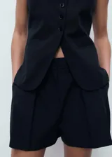 Short de tiro alto con diseño recto y detalle de pinzas delanteras. Cuenta con dos bolsillos laterales y cierre oculto de botón, gancho y cremallera.