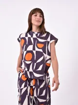 Remera blanca de manga corta con cuello redondo y un estampado abstracto en blanco y negro.