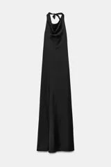 Vestido largo de satén con cuello halter y escote fluido. Presenta un diseño de espalda descubierta con cierre de cremallera oculta y lazada ajustable en el cuello.