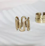 Anillo de bronce dorado con forma de onda.