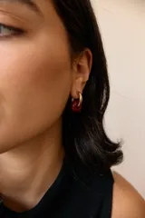 Aros dorados con dije circular de piedra natural negra.