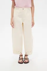 Pantalón jean slouchy de tiro alto, color natural, con detalle de bordadoado en el borde inferior.