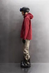 Cazadora deportiva de esquí con diseño bicolor en tonos negro y verde oliva. Presenta capucha amplia con visera, cierre frontal con cremallera termosellada, bolsillos frontales y en manga con cierres impermeables, y aberturas de ventilación en las axilas. Incluye faldón interior antinieve, puños ajustables y tecnología de rescate RECCO.