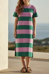 Vestido midi de tejido suave y ligero, con cuello redondo y mangas cortas. Presenta un patrón de rayas horizontales anchas en color verde oscuro y rosado. El vestido tiene aberturas laterales en el ruedo.