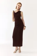 Vestido midi marrón sin mangas, de punto suave, con escote drapeado y cuentas decorativas irregulares en el tirante derecho. Presenta frunces en el lateral con efecto drapeado.