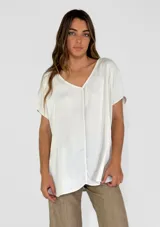 Blusa blanca de mangas cortas con escote en V y corte holgado.
