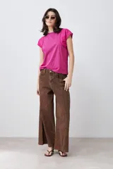 Remera fucsia de algodón con mangas cortas que presentan detalles de broderie y costuras decorativas.