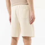 Bermuda blanca de felpa ligera con bolsillos laterales y cintura elástica con cordón ajustable.