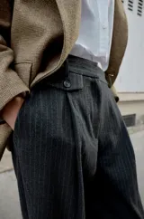 Pantalón de tiro medio con pinzas delanteras y pernera recta. Cuenta con bolsillos frontales, falsos bolsillos traseros de vivo y cierre frontal con cremallera, botón interior y ganchos.