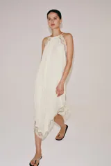 Vestido largo ZARA Woman Collection confeccionado en hilatura de viscosa de color crudo, con cuello halter, tirantes finos, detalles de encaje a tono y bajo asimétrico.