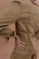 Chaqueta de jean azul, de corte entallado, con cuello camisero, cierre frontal con botones y bolsillos delanteros con solapa.
