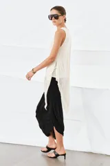 Top color beige con cuello redondo, manga sisa y bajo asimétrico. Confeccionado en hilatura de lyocell con efecto doble.