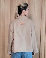 Chaqueta de textura bouclé en color bordó, con corte oversize, cuello camisero, cierre frontal y bolsillos laterales.