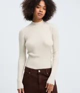 Blusa rectilínea de punto ligero en color beige, de manga larga y cuello alto, con diseño acanalado.