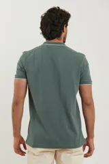 Chomba azul marino de piqué con cuello clásico y tapeta de dos botones. Detalles de ribete blanco en cuello y mangas.