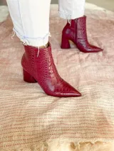 Botas cortas color marrón con estampado de cocodrilo, punta fina y taco de 8.5 cm.