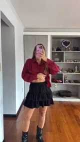 Pollera negra de corte acampanado con diseño de volados escalonados y short incorporado, con cintura elástica.