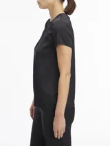 Blusa negra de satén con mangas cortas, cuello redondo con abertura en forma de V y cierre metálico.