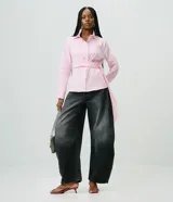 Pantalón barrel de jean color negro con lavado desteñido, cintura alta con trabillas, cierre frontal de botón y cremallera, bolsillos funcionales y corte amplio con ruedo ajustado.