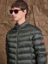 Campera puffer de plumas en color azul marino, con cierre frontal, cuello alto y diseño acolchado horizontal.