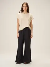 Pantalón de lino color tostado, de corte amplio y fluido con piernas acampanadas.