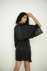 Bata corta de seda negra, con mangas anchas terminadas en encaje. Se ajusta a la cintura con un lazo del mismo material.