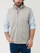 Chaleco de hombre con exterior tejido jaspeado e interior de micropolar. Cuenta con cierre frontal completo, cuello alto y tres bolsillos frontales con cierre.