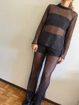 Polera de red negra con cuello alto y mangas largas.