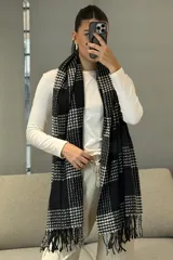 Bufanda rectangular con diseño de cuadros escoceses en blanco y negro, con flecos en los extremos.