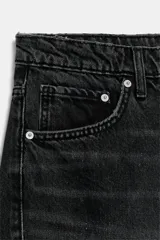 Jeans de tiro medio con diseño baggy barrel, cinco bolsillos y costuras laterales torcidas. Presenta cierre frontal con cremallera y botón metálico.