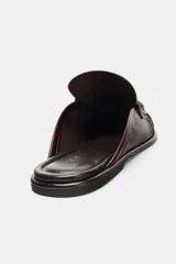 Mocasín tipo mule destalonado en piel color marrón oscuro, con detalle fruncido en la puntera redonda y antifaz en el empeine.