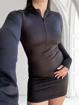 Minivestido negro ajustado al cuerpo, de mangas largas y cuello alto con cierre metálico frontal.