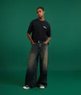 Pantalón de jean con corte baggy, de tiro alto y diseño holgado. Presenta un acabado desgastado y trabillas en la cintura.