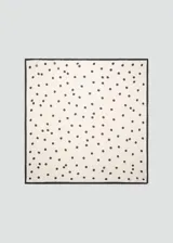 Pañuelo cuadrado de tejido satinado color crudo con estampado de lunares negros y borde oscuro.