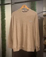 Buzo beige de punto nantes con cuello redondo y mangas largas.