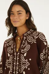 Sweater de punto color marrón con diseño estampado estilo paisley en tono crudo, cuello camisero con escote en V y cordones decorativos, mangas largas y calce amplio.