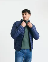 Campera acolchada tipo puffer en color gris, con cierre frontal, cuello alto y puños elásticos.